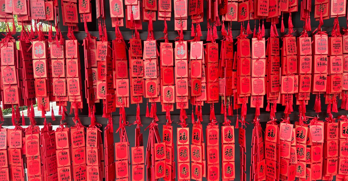 A colorful display of traditional red hanging tags used for wishes in Asian cultures.